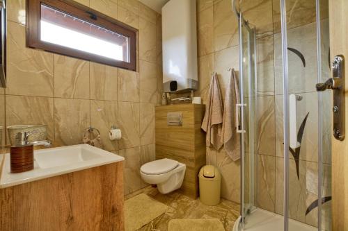 un bagno con wc, lavandino e doccia di Oaza Spokoju - Domki a Polanica-Zdrój