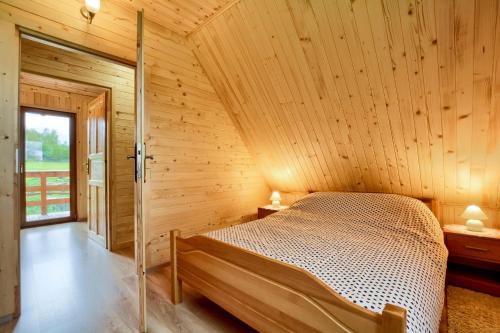 um quarto com uma cama num chalé de madeira em Oaza Spokoju - Domki em Polanica-Zdrój