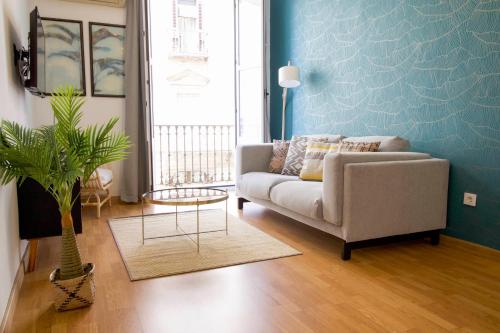 uma sala de estar com um sofá e uma mesa em Apartments Olé - Tetuán em Sevilha