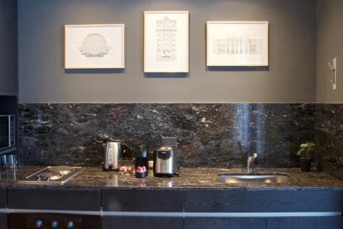 una encimera con dos lavabos y tres cuadros en la pared en Explore Palermo in Stunning and Chic Studio -1D- en Buenos Aires