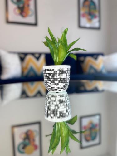 a white vase with a green plant in it at Flitwick Luxury Apartments in Flitwick