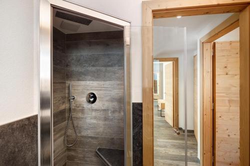 een badkamer met een douche en een glazen deur bij Petalo Rosina's Home in Livigno