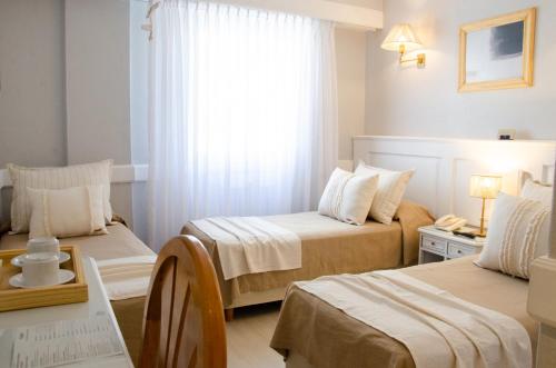 a hotel room with two beds and a window at Hotel Valles in Mar del Plata