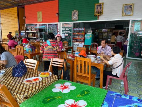 a group of people sitting at tables in a restaurant at บุญจินดา รีสอร์ท in Ban Phayom