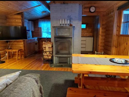 ein Wohnzimmer mit einem Kamin in einer Blockhütte in der Unterkunft Villa Latvus in Rovaniemi