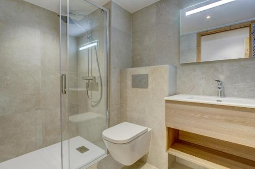 a bathroom with a shower and a toilet and a sink at Echo du Pleney A204 in Morzine