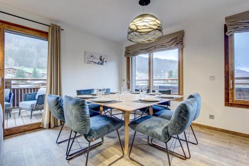 a dining room with a table and chairs and windows at Echo du Pleney A204 in Morzine