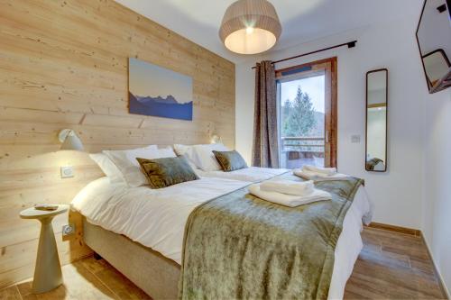 a bedroom with a bed with a wooden wall at Echo du Pleney A204 in Morzine