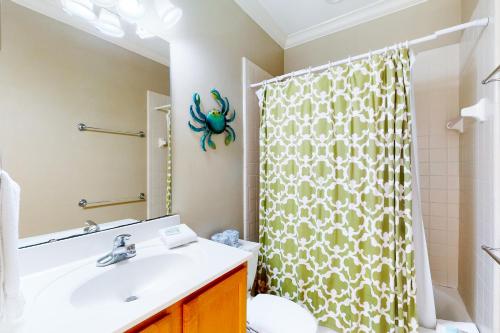 a bathroom with a sink and a shower curtain at Serenity Now in St. George Island
