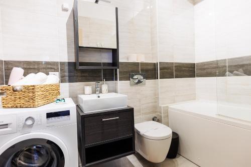 a bathroom with a washing machine and a sink at Touchdown Apartment near Bucharest Airport in Otopeni
