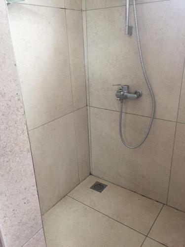 La salle de bains est pourvue d'une douche avec un pommeau de douche. dans l'établissement tina house, à Bel Ombre