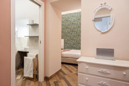 a small room with a bed and a mirror at Tredici Boutique Rooms in Naples