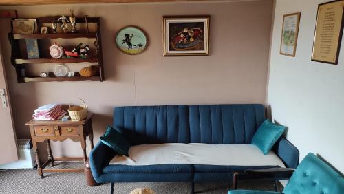 a blue couch in a living room with a table at Robinzonski smjestaj BB-HILL in Zabok