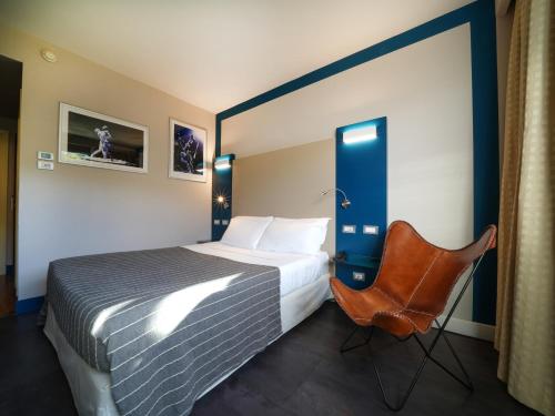 a hotel room with a bed and a chair at La Meridiana Bleisure Hotel in Perugia