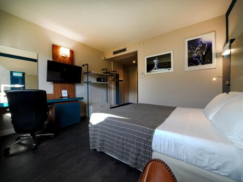 a hotel room with a bed and a desk and a computer at La Meridiana Bleisure Hotel in Perugia