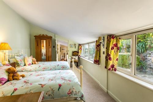 a bedroom with two beds and two windows at Pilgrim Corner in Minehead