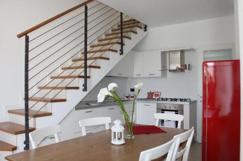 cocina y comedor con mesa y escalera en Grillo Casa Vacanze en Tessera