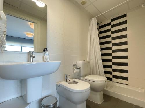 a white bathroom with a sink and a toilet at Apartamentos la Volta Aguamarina in Peñíscola