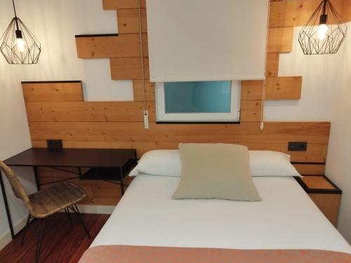 a bedroom with a white bed and a window at Pensión La Perla in Donostia-San Sebastián