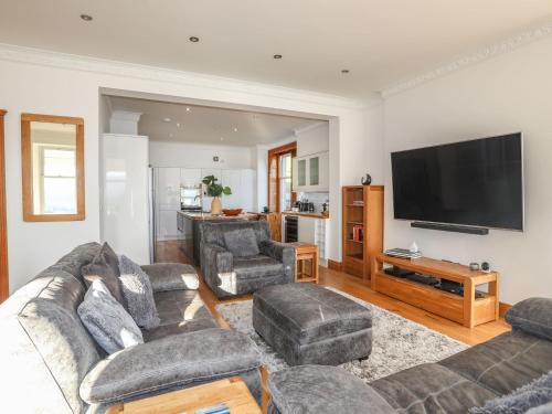 a living room with couches and a flat screen tv at Bryn Mel Manor Straits View in Menai Bridge
