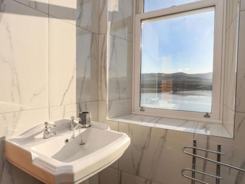 a white sink in a bathroom with a window at Bryn Mel Manor Straits View in Menai Bridge