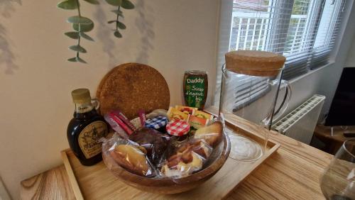 - une table avec un bol de nourriture et une bouteille de sauce dans l'établissement Beau studio très calme, parking privée gratuit, Netflix, à Linas