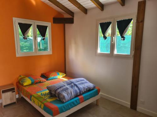 een slaapkamer met een bed en 2 ramen bij Bung-hello Village,Petit Bungalow confortable avec jacuzzi in Trois-Rivières