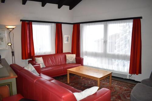 a living room with a red couch and a table at Arp (470 Bä) OG in Valbella