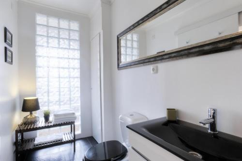 een badkamer met een zwarte wastafel en een raam bij BmyGuest - Castelo Stylish Flat in Lissabon