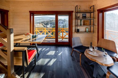 ツァルナ・グラにあるHouten Vakantiewoning "ReisnaarPolen" inclusief royaal ontbijt, sauna en gidsのテーブルと椅子、窓が備わる客室です。