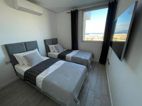 A bed or beds in a room at Ocean Garden Sunset Apartment - heated swimming pool Free WIFI