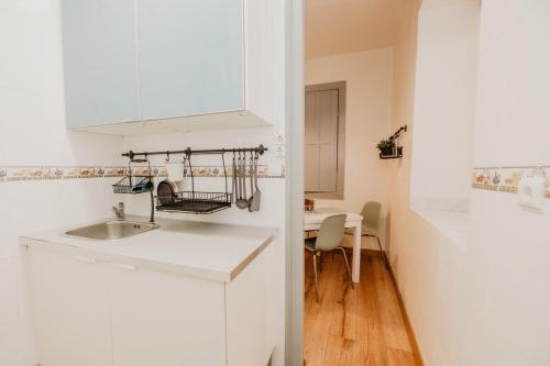 uma cozinha branca com um lavatório e uma mesa em Romantic Blue em Lisboa
