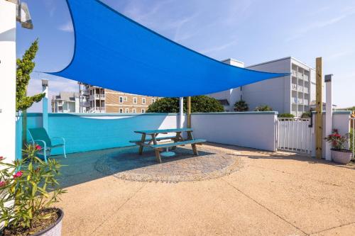 a blue umbrella over a bench on a patio at John Yancey Oceanfront Inn in Kill Devil Hills