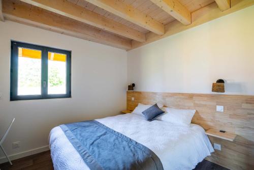 una camera con un grande letto in una stanza con soffitti in legno di Les Cottages de Ripaille a Thonon-les-Bains