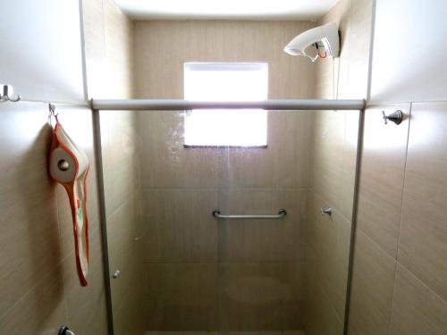 y baño con ducha y puerta de cristal. en Oásis do Mutá Residencial, en Porto Seguro