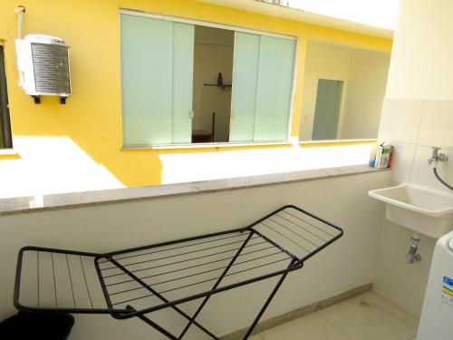 estante en el baño con lavabo y espejo en Residencial Praia dos Corais, en Santa Cruz Cabrália