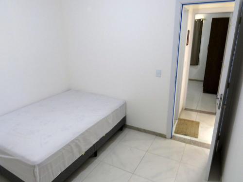 Habitación blanca pequeña con cama. en Residencial Praia dos Corais, en Santa Cruz Cabrália