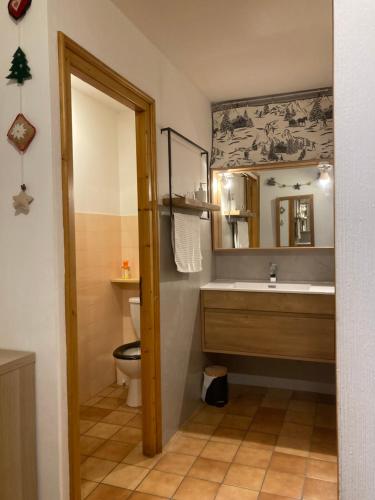 een badkamer met een wastafel, een toilet en een spiegel bij Demi Chalet Le LACHAT in Notre-Dame-de-Bellecombe