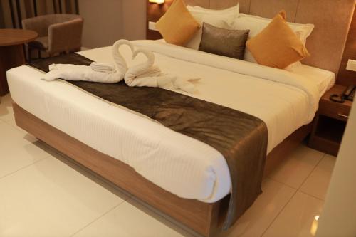 a large bed with towels on it in a room at Hotel Kottayam Grand in Kottayam