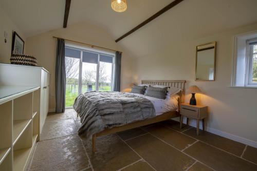 um quarto com uma cama e uma grande janela em LaLo em Maunby