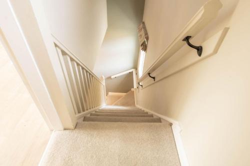 a staircase in a home with white walls and white carpet at 1 School Lane in Malton