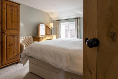 1 dormitorio con cama blanca y ventana en 1 School Lane en Malton