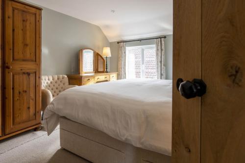 a bedroom with a white bed and a window at 1 School Lane in Malton