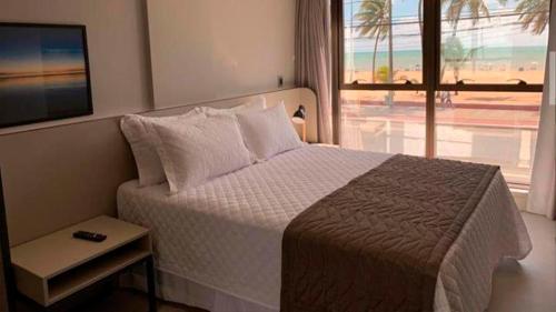 a bedroom with a bed with a view of the beach at Infinity at the Sea by Matka in João Pessoa