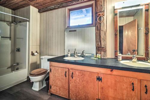 a bathroom with two sinks and a toilet and a window at New Paris Cabin about 11 Mi to Shawnee State Park 