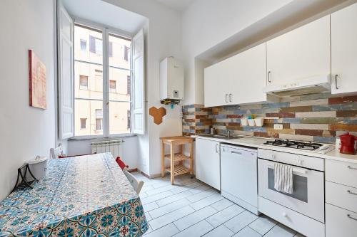 a kitchen with white cabinets and a table at Casa al Viminale in Rome