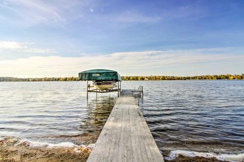 a boat is docked at a dock on a lake at Pelican Lake Getaway on Stunning Peninsula! in Pequot Lakes