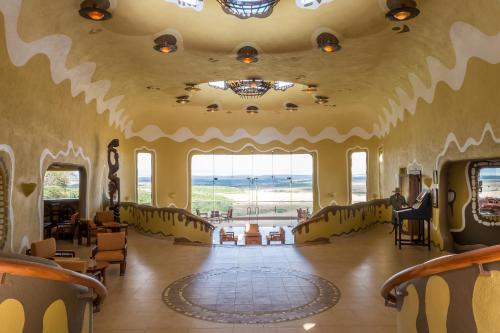 une grande pièce avec des chaises et une grande fenêtre dans l'établissement Mara Serena Safari Lodge, à Lolgorien
