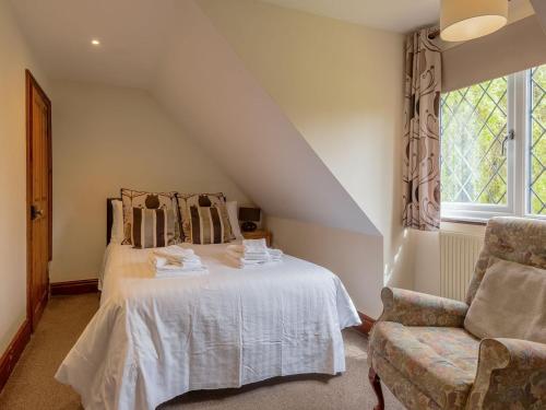 um quarto com uma cama, uma cadeira e uma janela em Riverside Cottage-uk41439 em Brandon