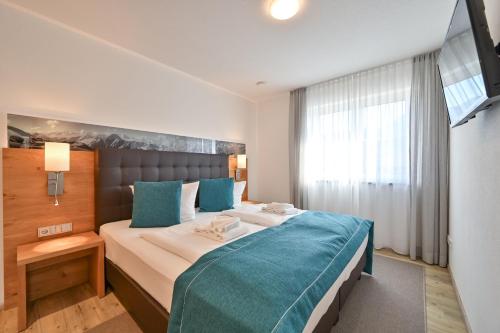 een slaapkamer met een groot bed en een blauwe deken bij Landhaus am See Appartement LH 02 in Schwangau